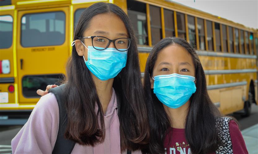 Two people wear masks